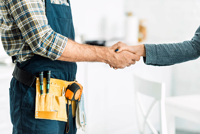 man shaking hands with a plumber