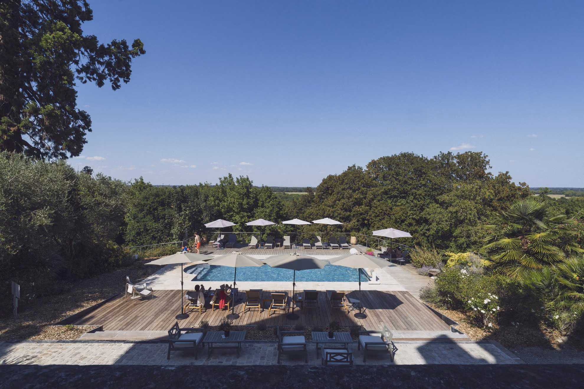 Piscine extérieure du Château des Forges avec vue sur le parc en Anjou