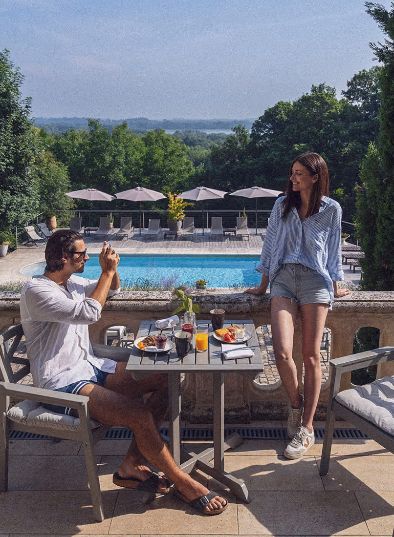 A couple having breakfast on the terrace at Château des Forges