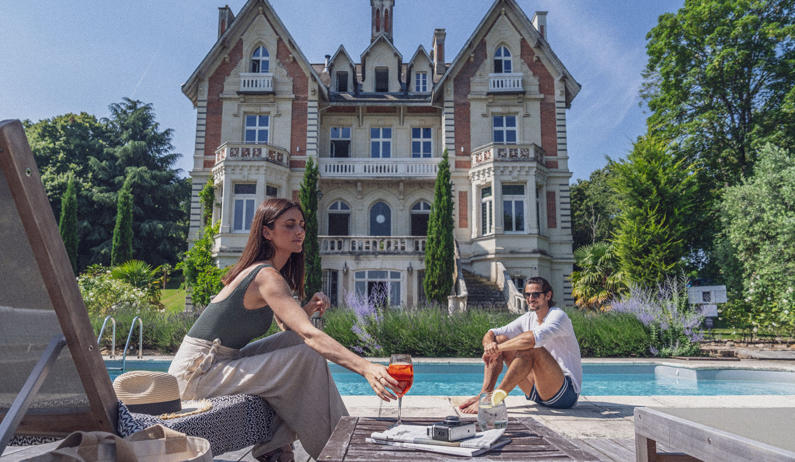 Clients apéritif devant la piscine au Château des Forges