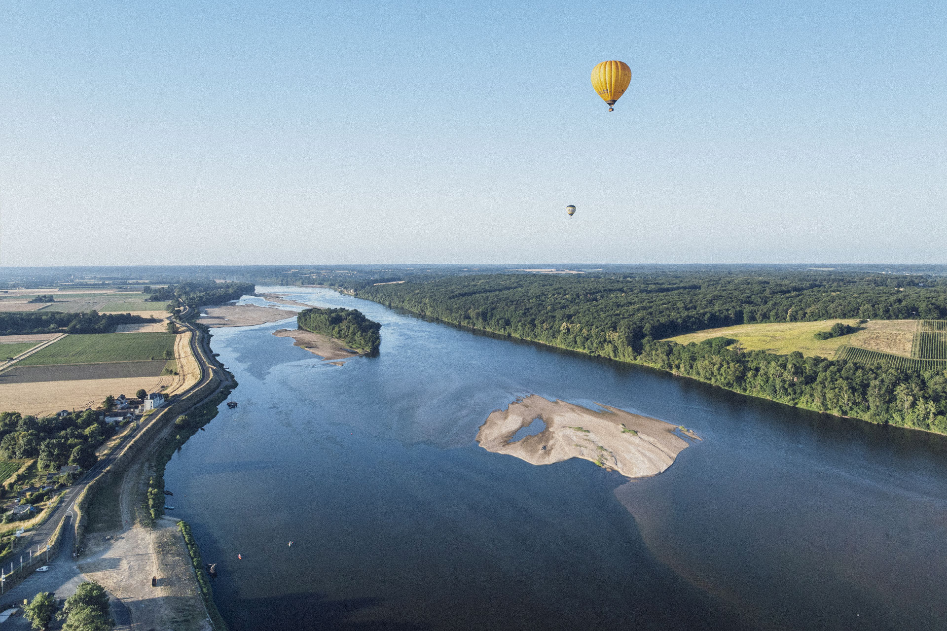Vue aérienne de la Loire en Anjou avec un banc de sable et des Montgolfières dans le ciel