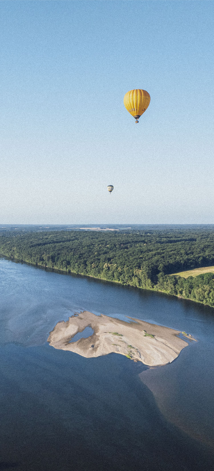 Vue aérienne de la Loire en Anjou avec un banc de sable et des Montgolfières dans le ciel
