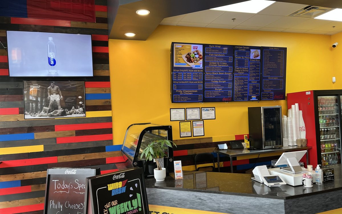 The Wing Dash counter in Dallas with menu boards on a yellow wall