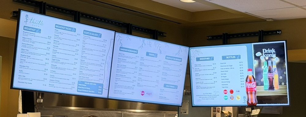 Three menu boards over the counter at Thistle Cafe in Austin