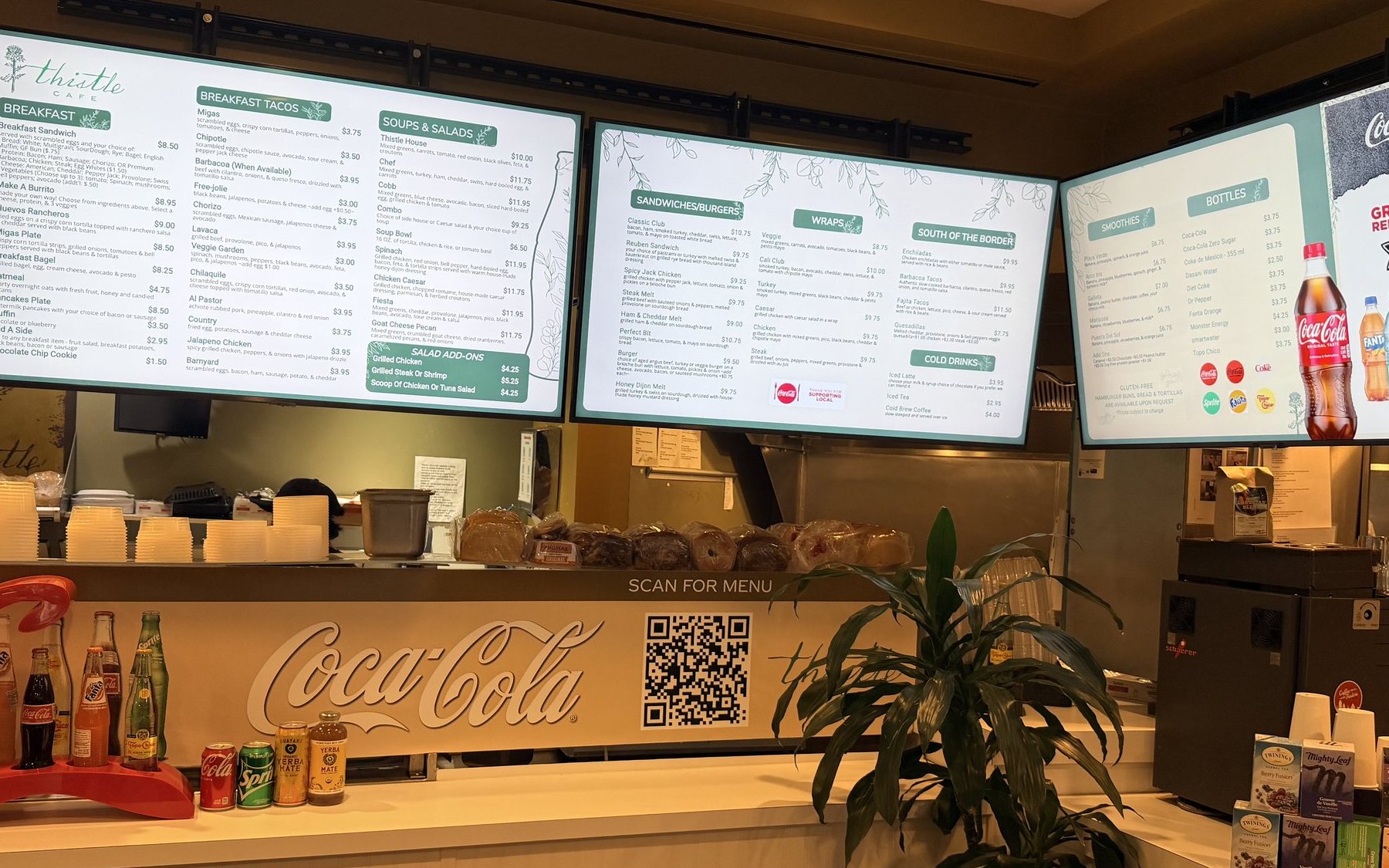 Three menu boards over the counter at Thistle Cafe in Austin, with a Scan for menu QR code on the counter sign below