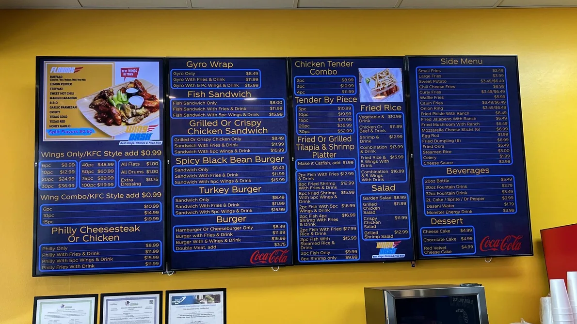 Four dark-blue menu boards on a yellow wall