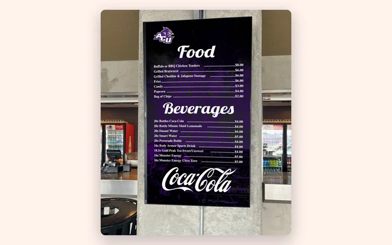 A tall portrait menu board listing food and beverages at a university food venue