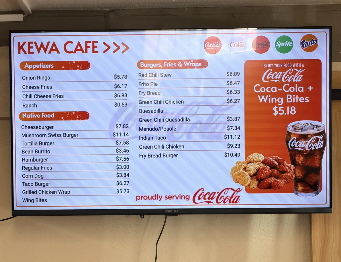 The Kewa Cafe menu board, with a Coca-Cola and Wing Bites combo panel at $5.18