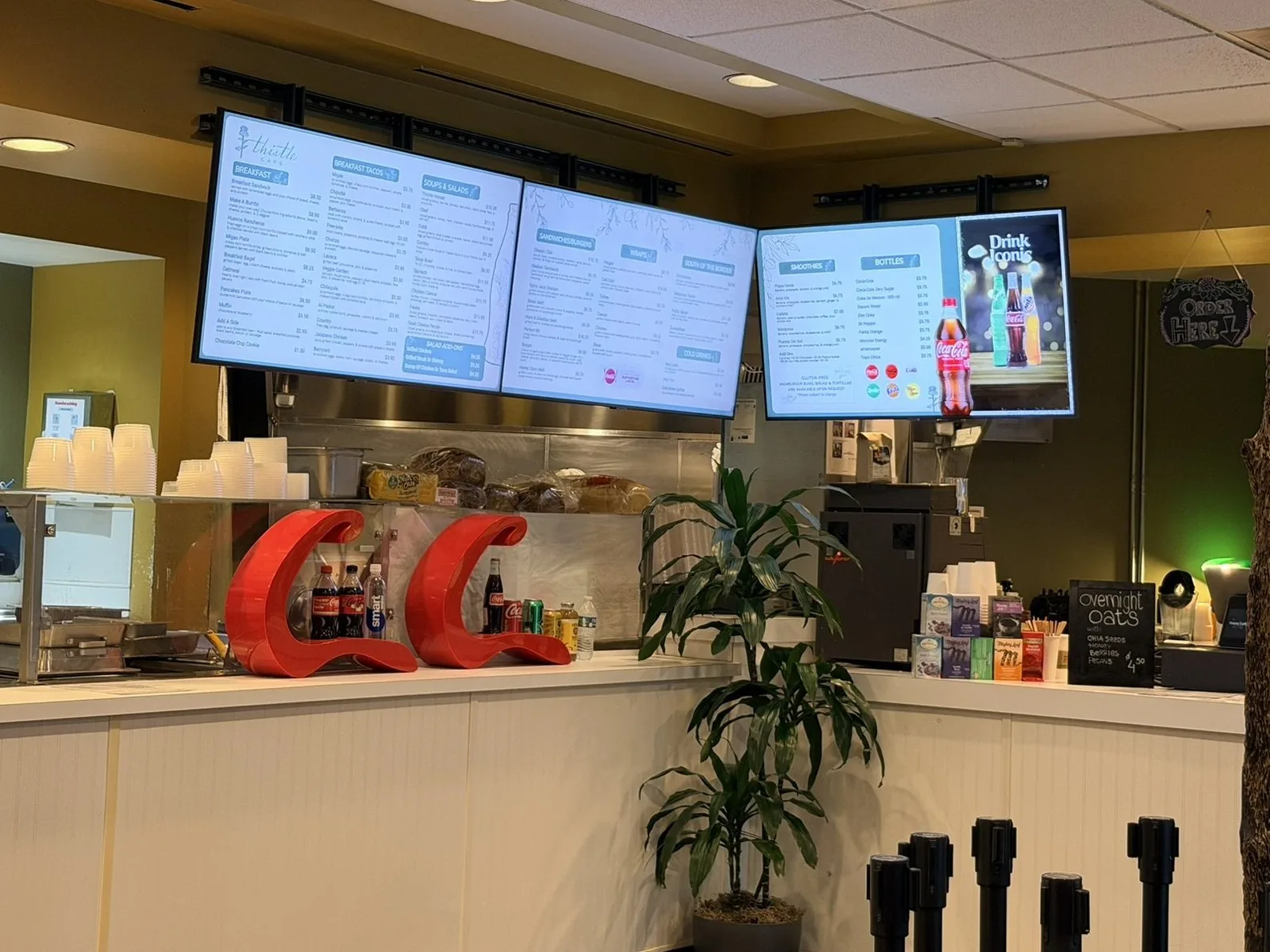 Three menu boards over the counter at Thistle Cafe in Austin