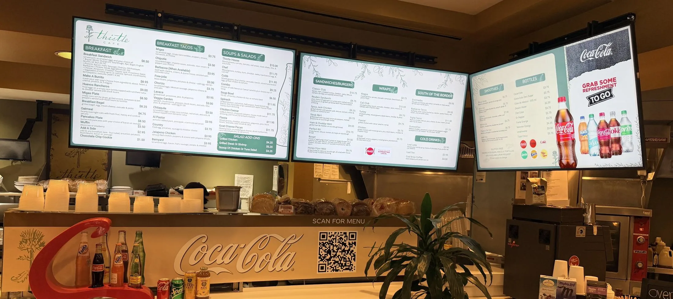 The counter at Thistle Cafe in Austin, with three menu boards above it and a Scan for menu QR code on the counter