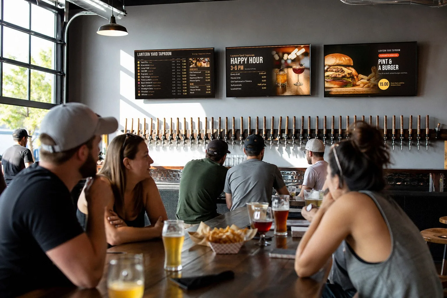 Illustration of a brewery taproom: guests with pints at a table, and three TVs over a long row of beer taps showing a 12-tap beer list, a happy hour slide and a Pint and a Burger special