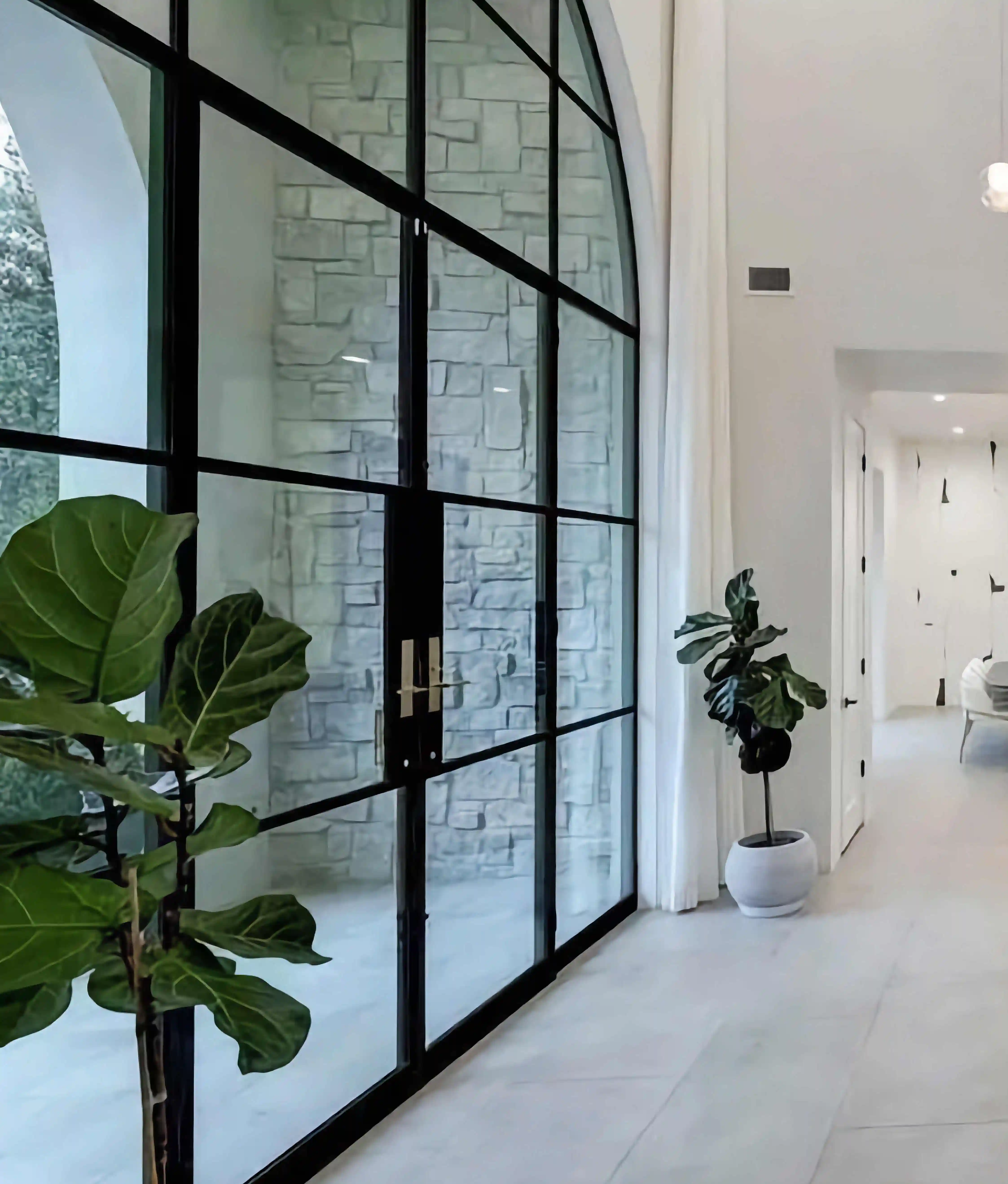 inside a white home with a large glass and black iron wall to the left covering the whole wall