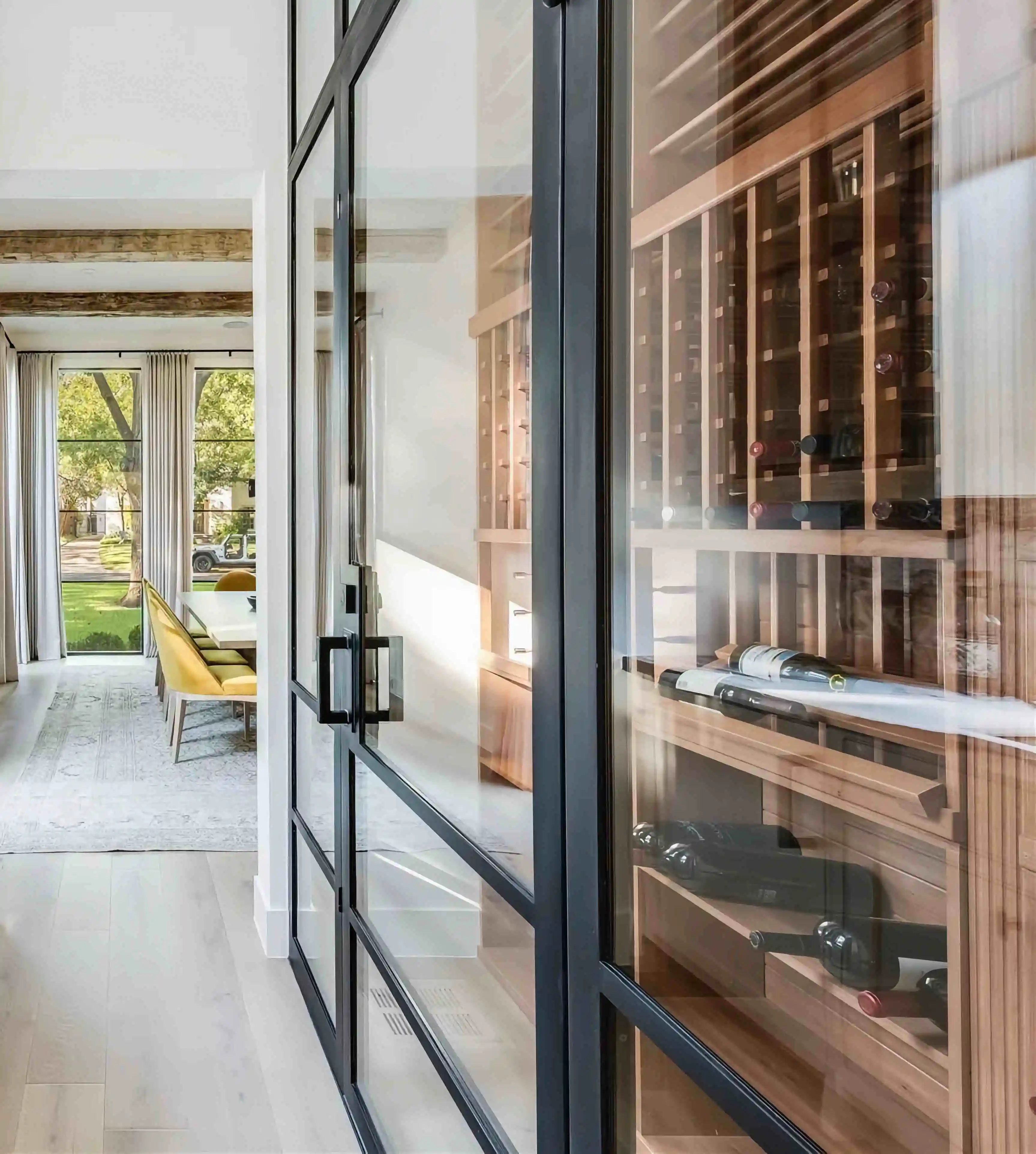a close up image of a wine room inside of a home with a large glass ad black iron door incasing it