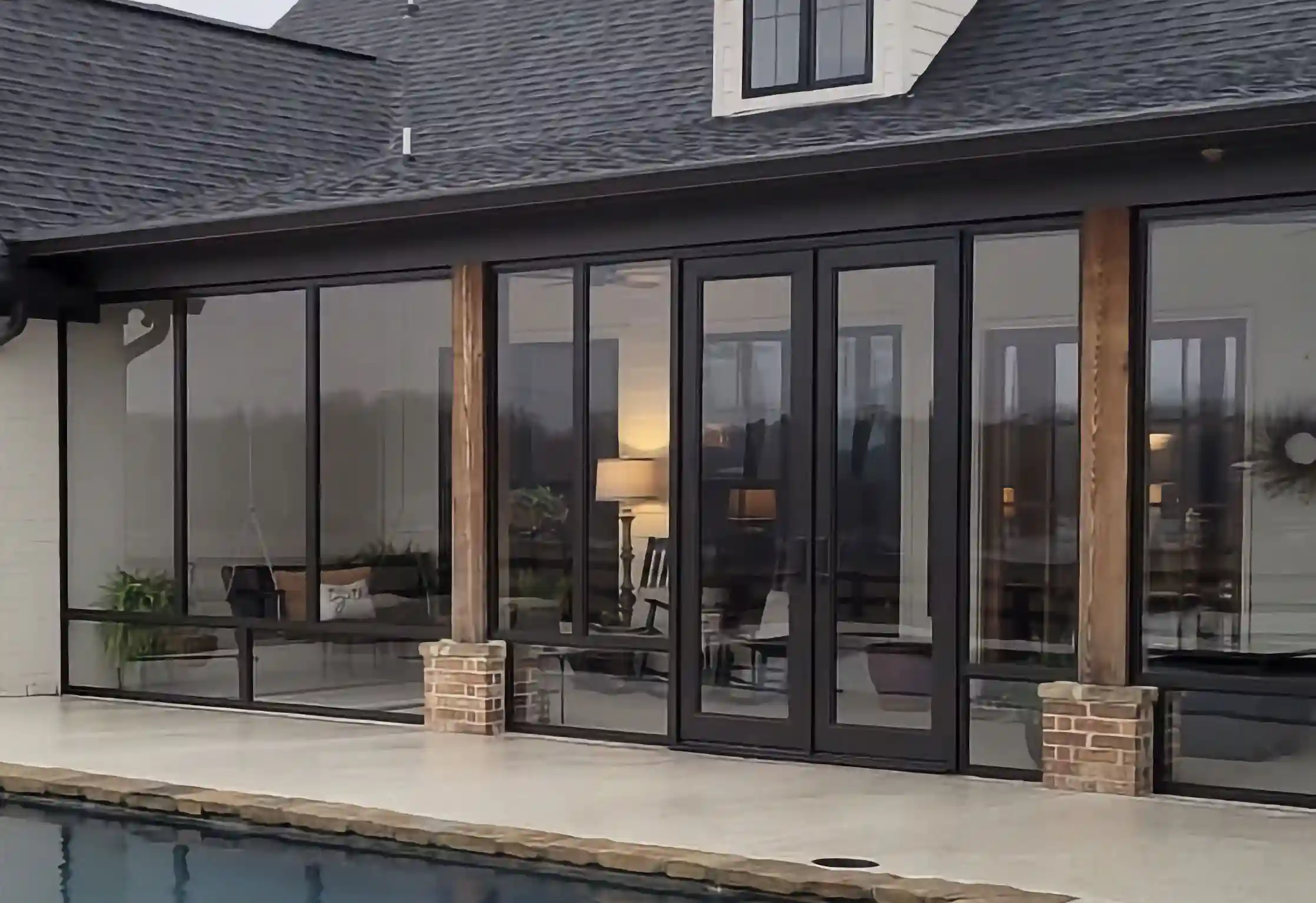 a home viewed from the back with the entire back being a large glass wall with minor brick details