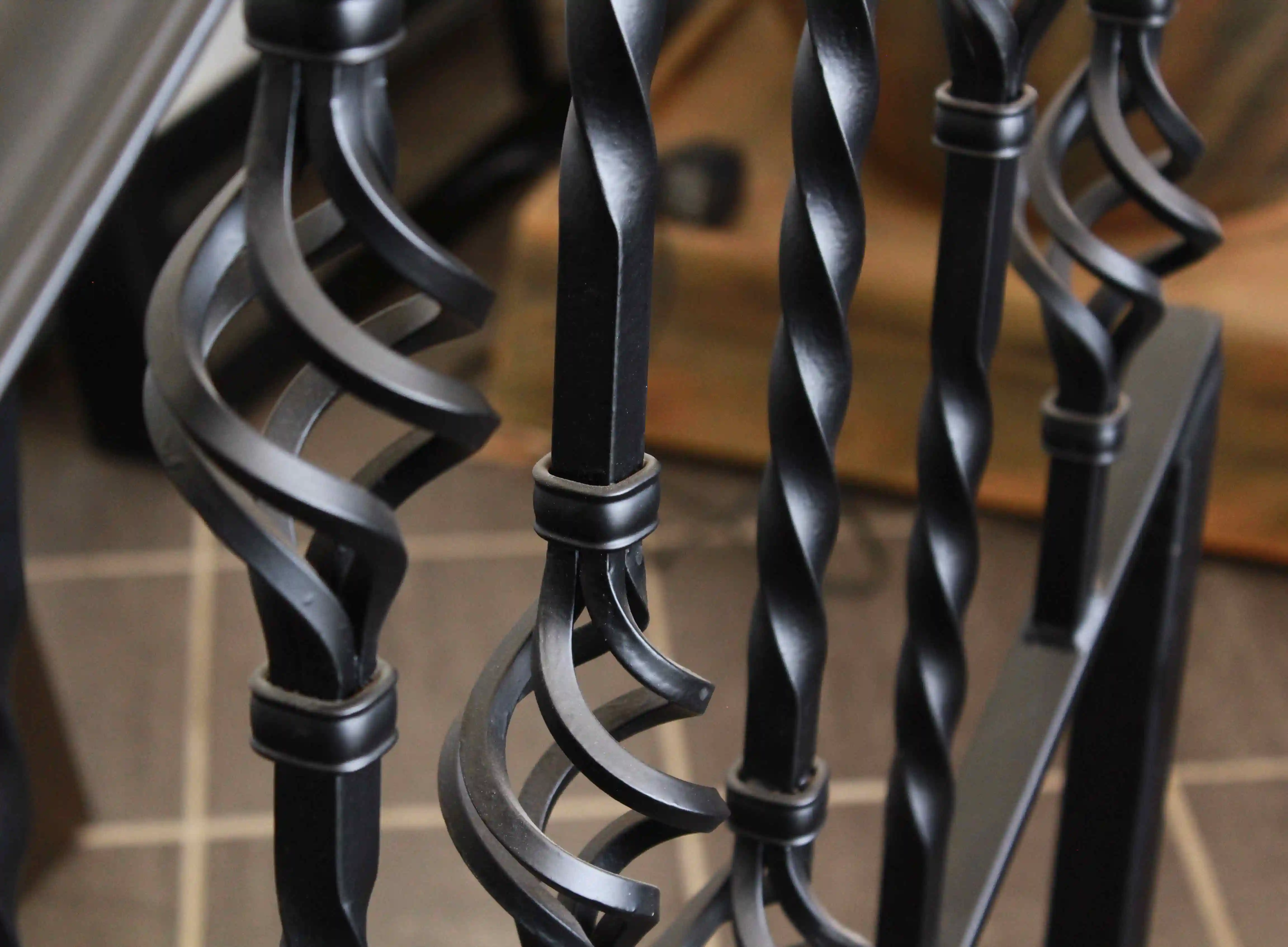 a very close up detail picture of a glossy black iron railing with a large swirl detail