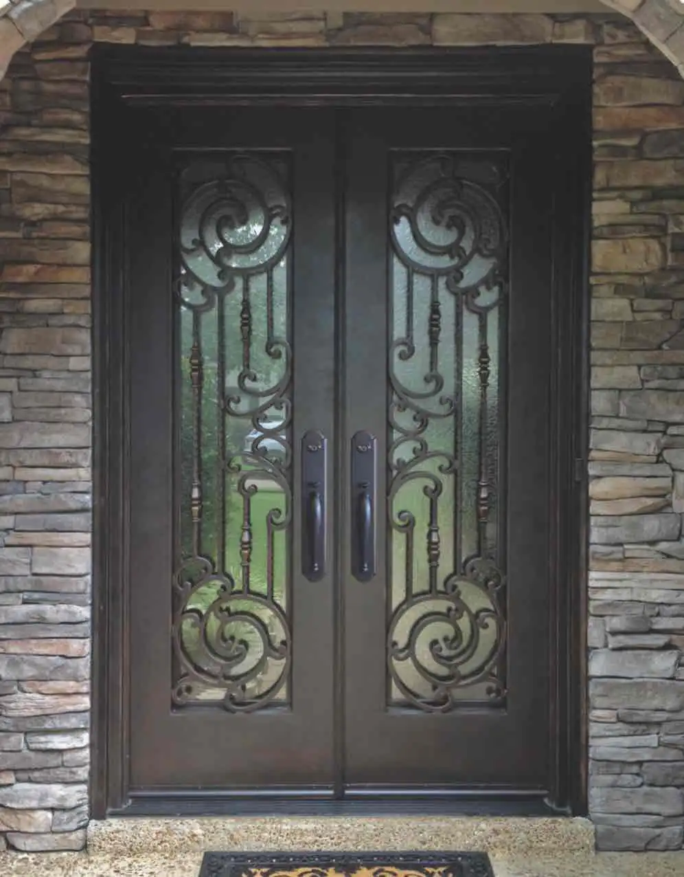 a black iron double door with large panes of glass on each door with intricate black iron swirls on each