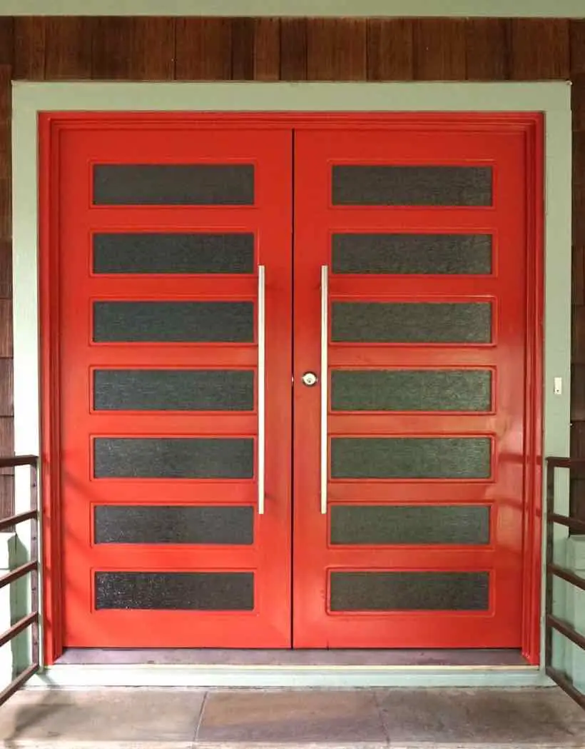 red iron front double entry door of a home with glass panels