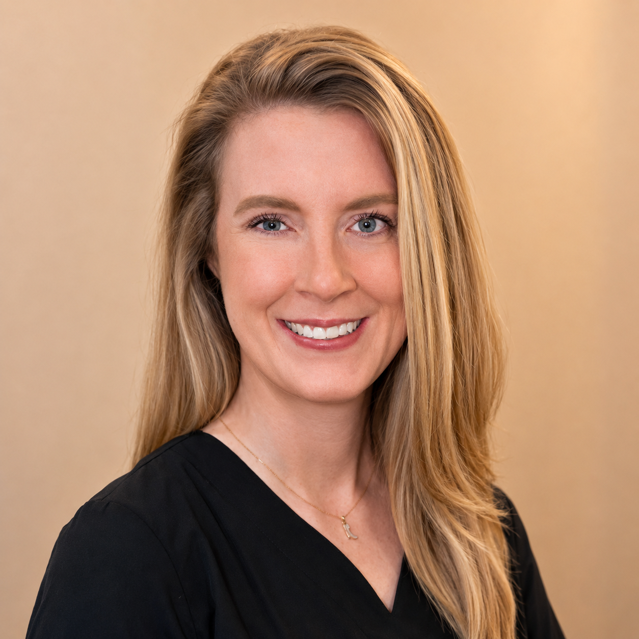 Headshot of Brooke, Dental Assistant, smiling in black scrubs against a neutral background