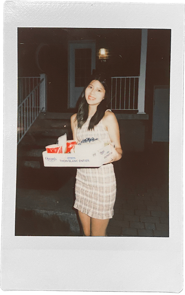 Stephanie holding a box of groceries outdoors at night, shot on film