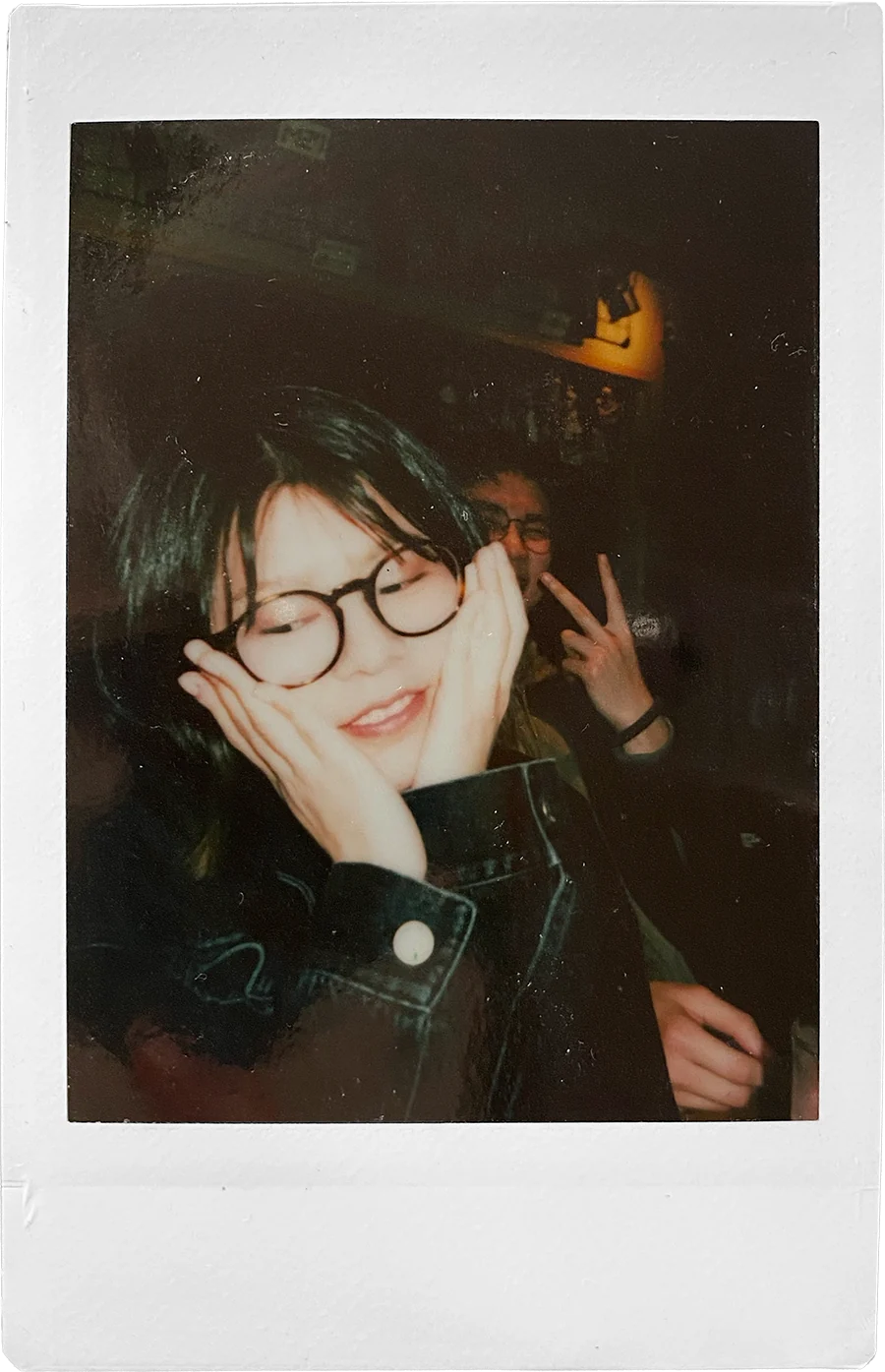 Stephanie wearing round glasses and a denim jacket, shot on film at a party