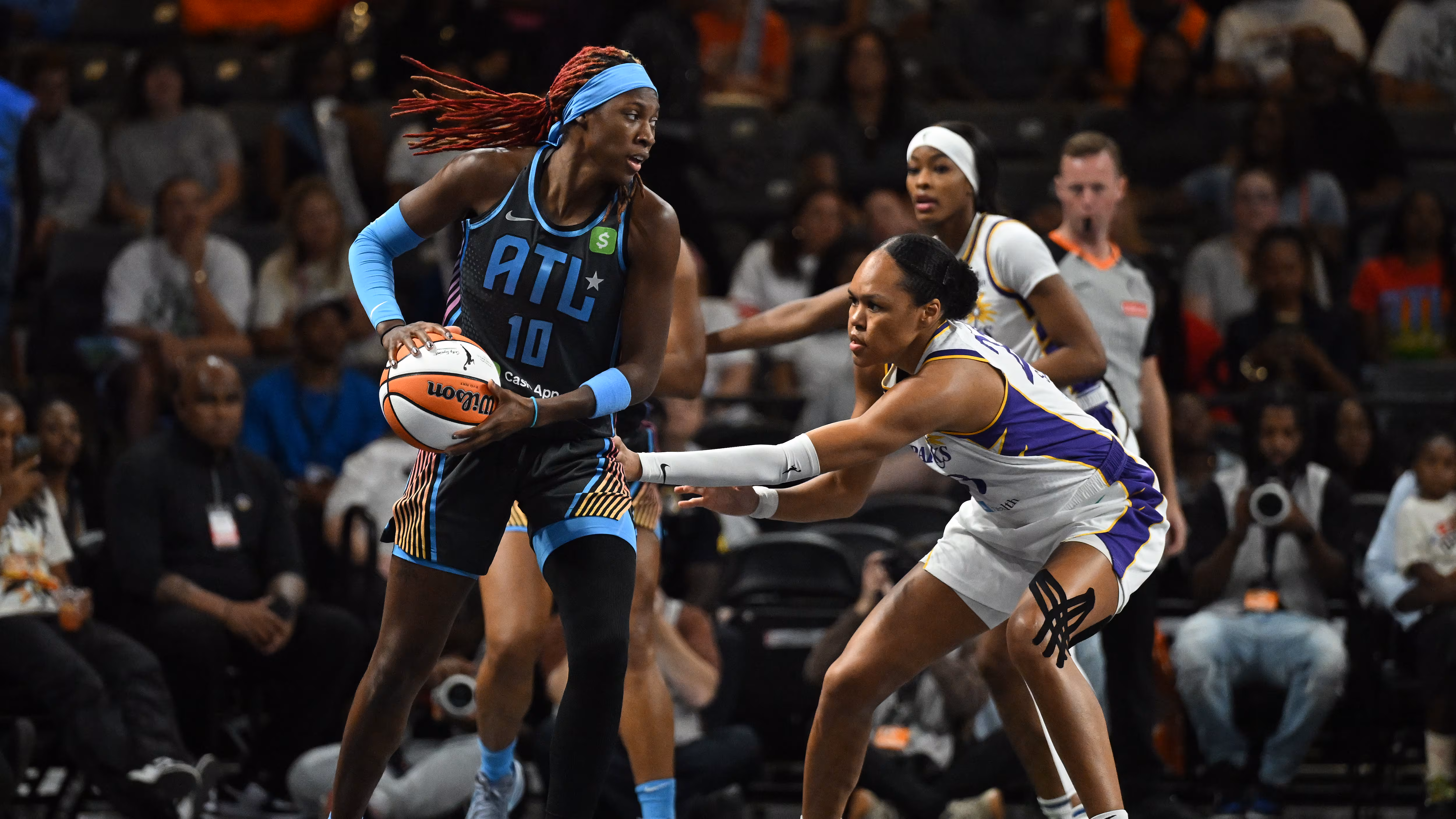 Atlanta Dream basketball player in uniform featuring Tantrum Agency rebrand of Atlanta Dream holding ball guarded by opponent in white and purple uniform.