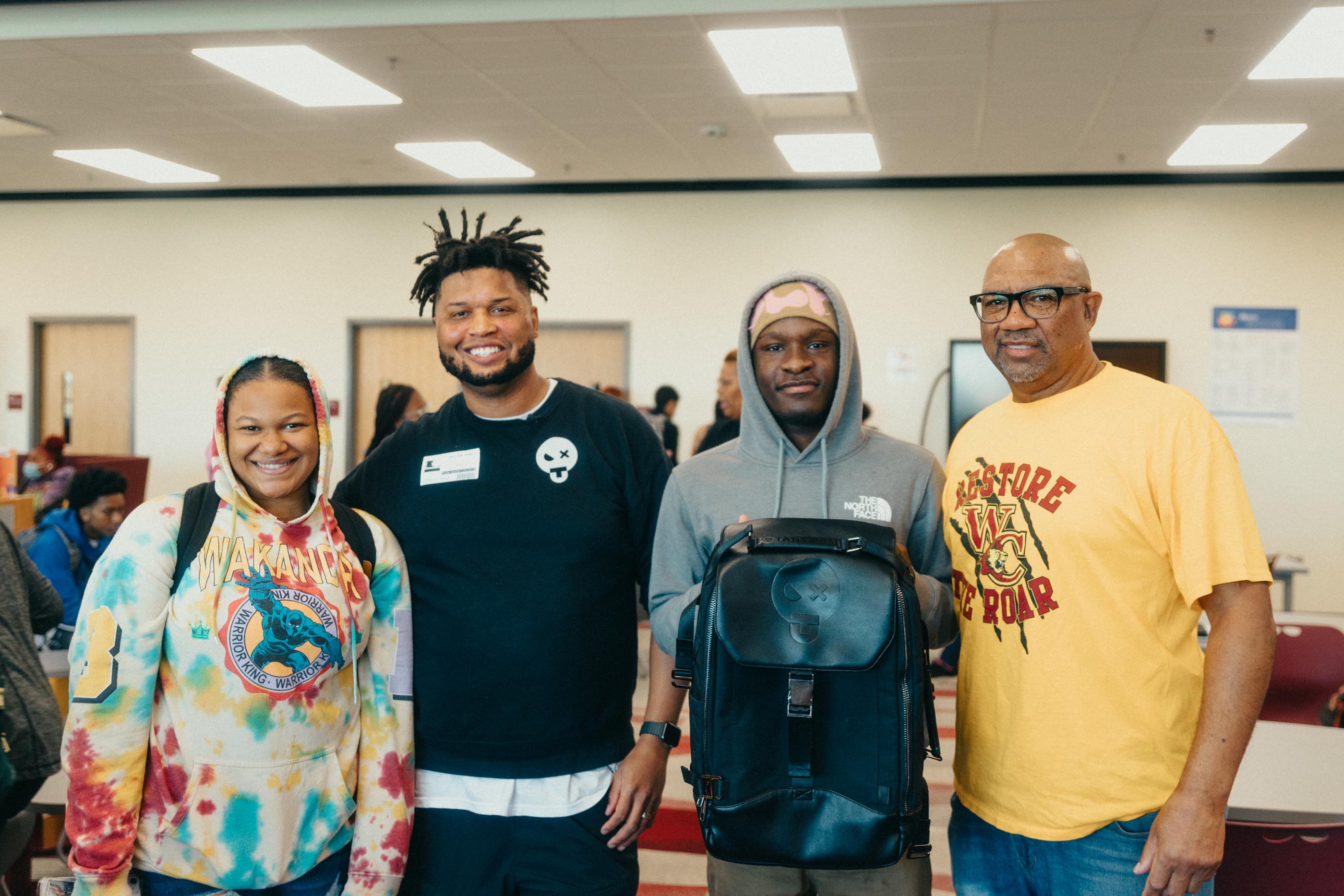 Founder of Tantrum Agency smiles with students and teachers on a classroom at West Charlotte High School