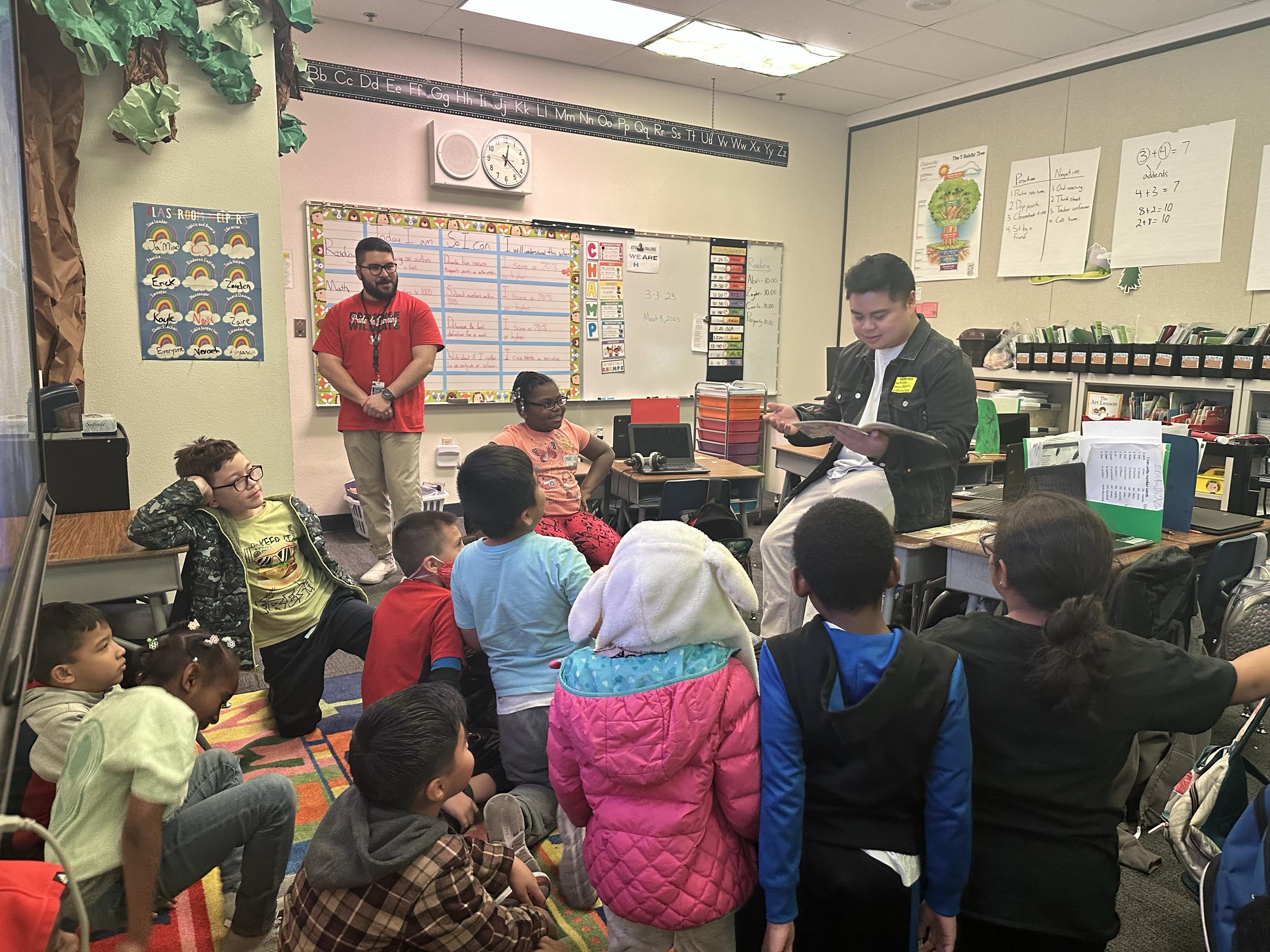 Tantrum Agency team member, Michael Gutierrez-Nery reading to students and participating in hands-on community volunteer work