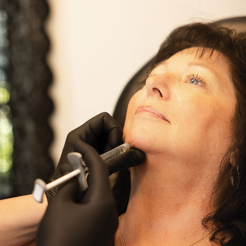 Provider performing a chin dermal filler treatment