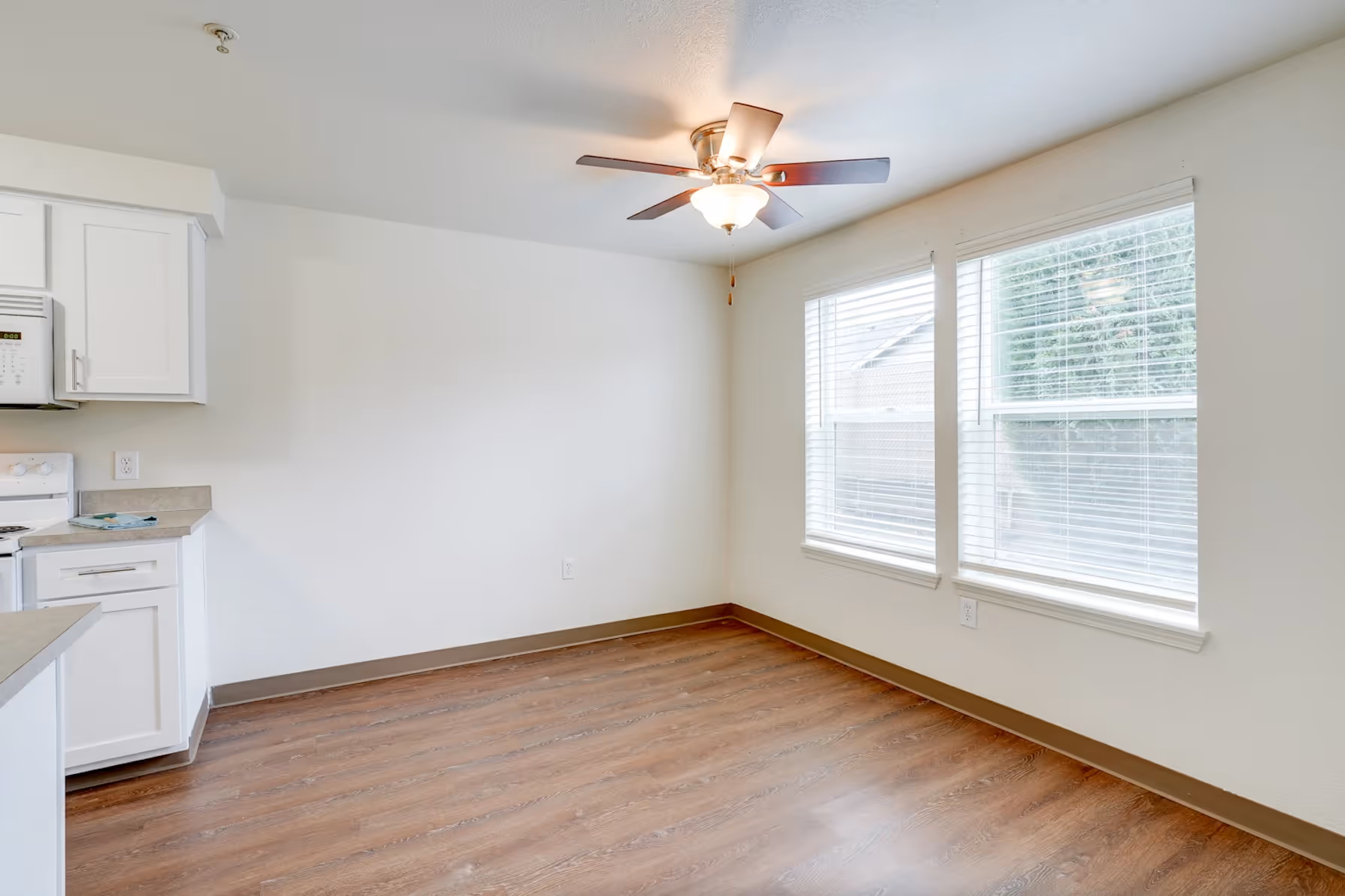 Dining area unfinished with ceiling fan and large window