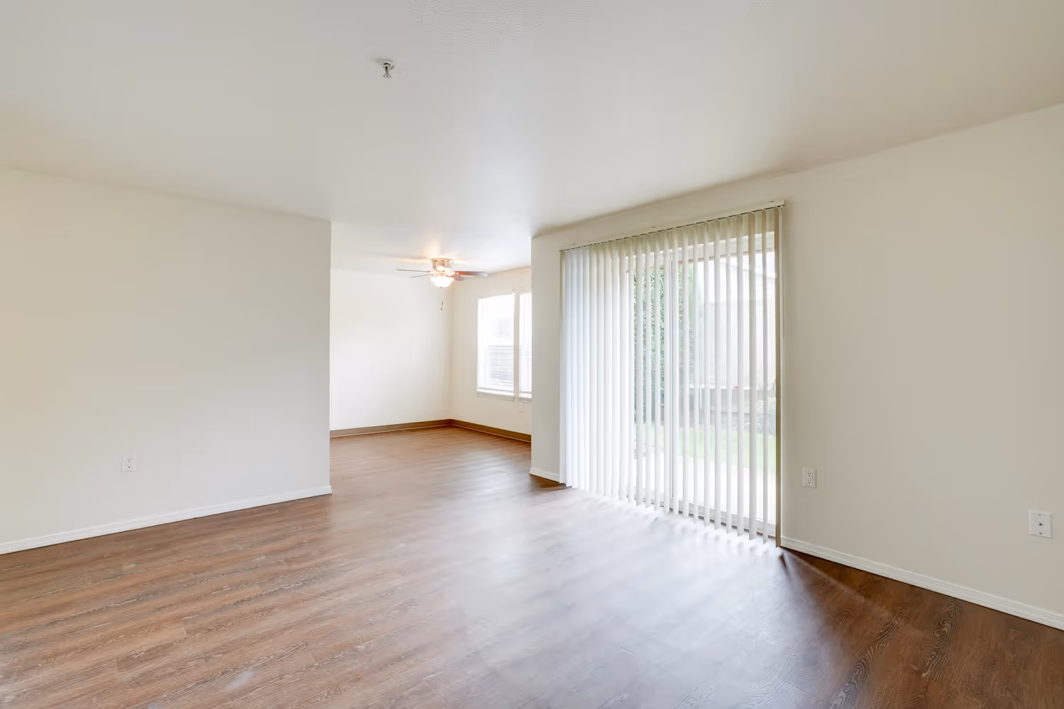 Unfurnished Living area with view of balcony entrance and dining area