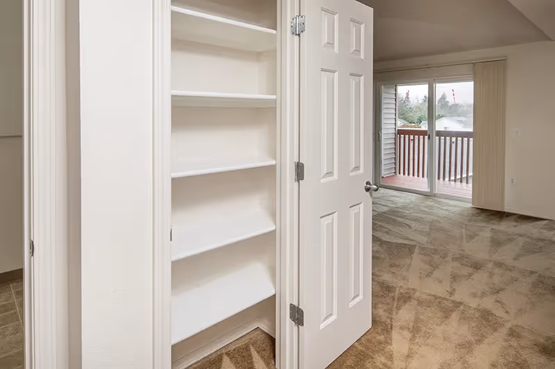 Linen closet near living area with view of balcony