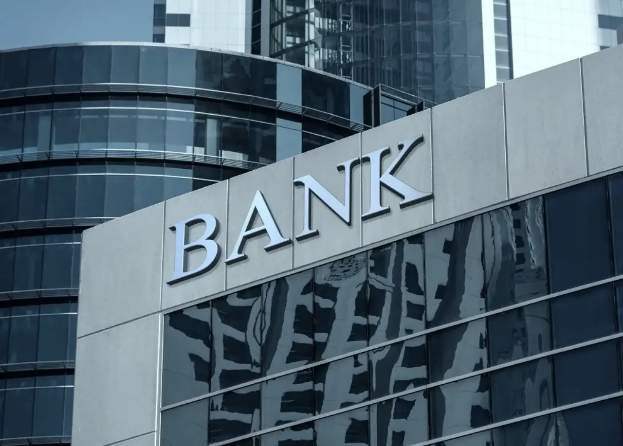 Victorins - modern bank building facade with large silver BANK letters and reflective glass windows