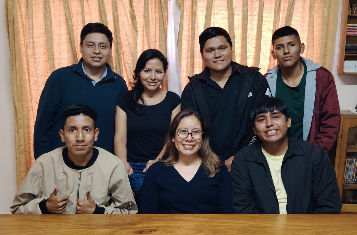 Seven people posing together behind a table.