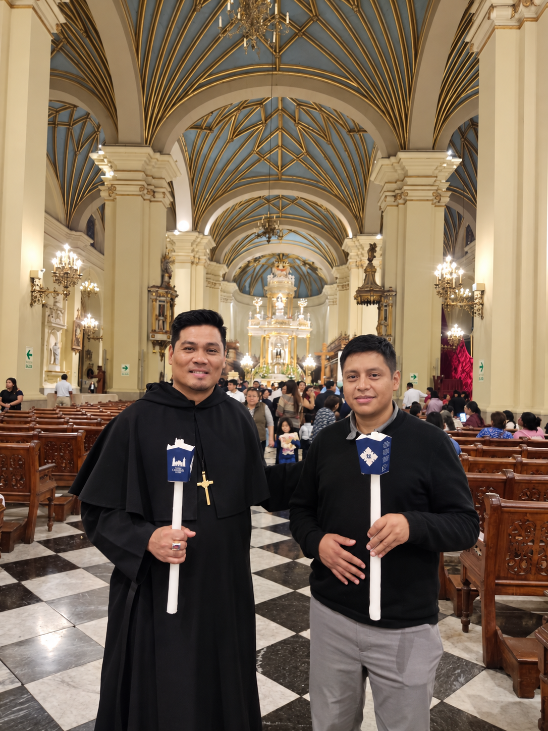 Two men holding candles inside a church.