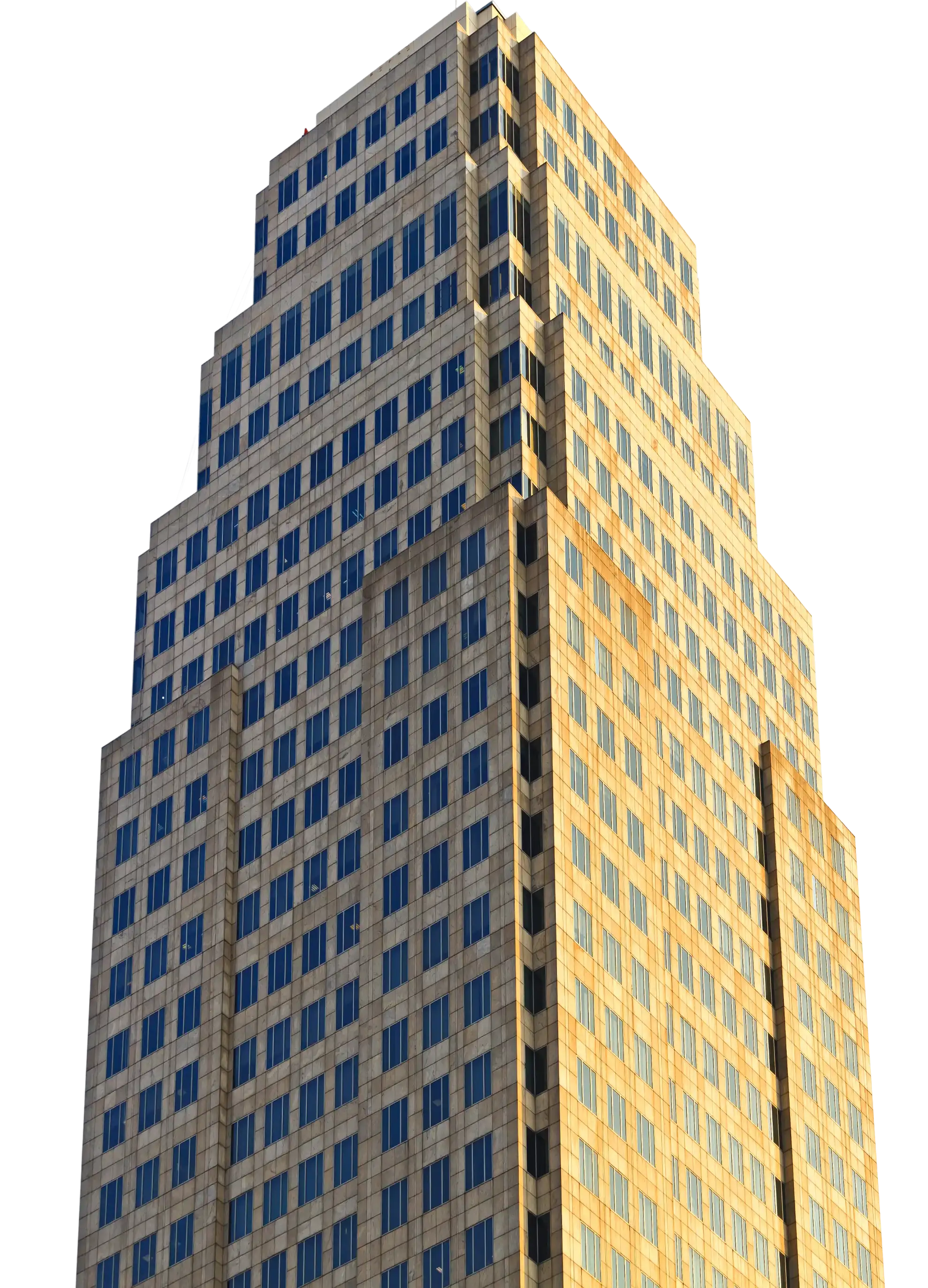 Tall office building facade with many blue windows lit by golden sunlight.
