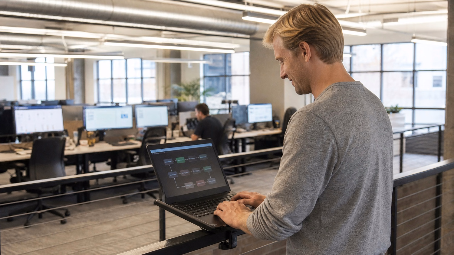Man on balcony with laptop reviewing BEC incident response flowchart