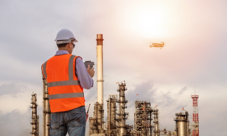 Engineer construction used drone take photo aerial view for inspection and survey at oil refinery factory background.