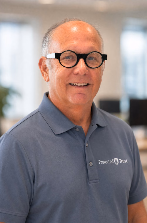 Crawford Weimann, Protected Trust MSP team member, smiling in branded polo shirt at Orlando IT company office
