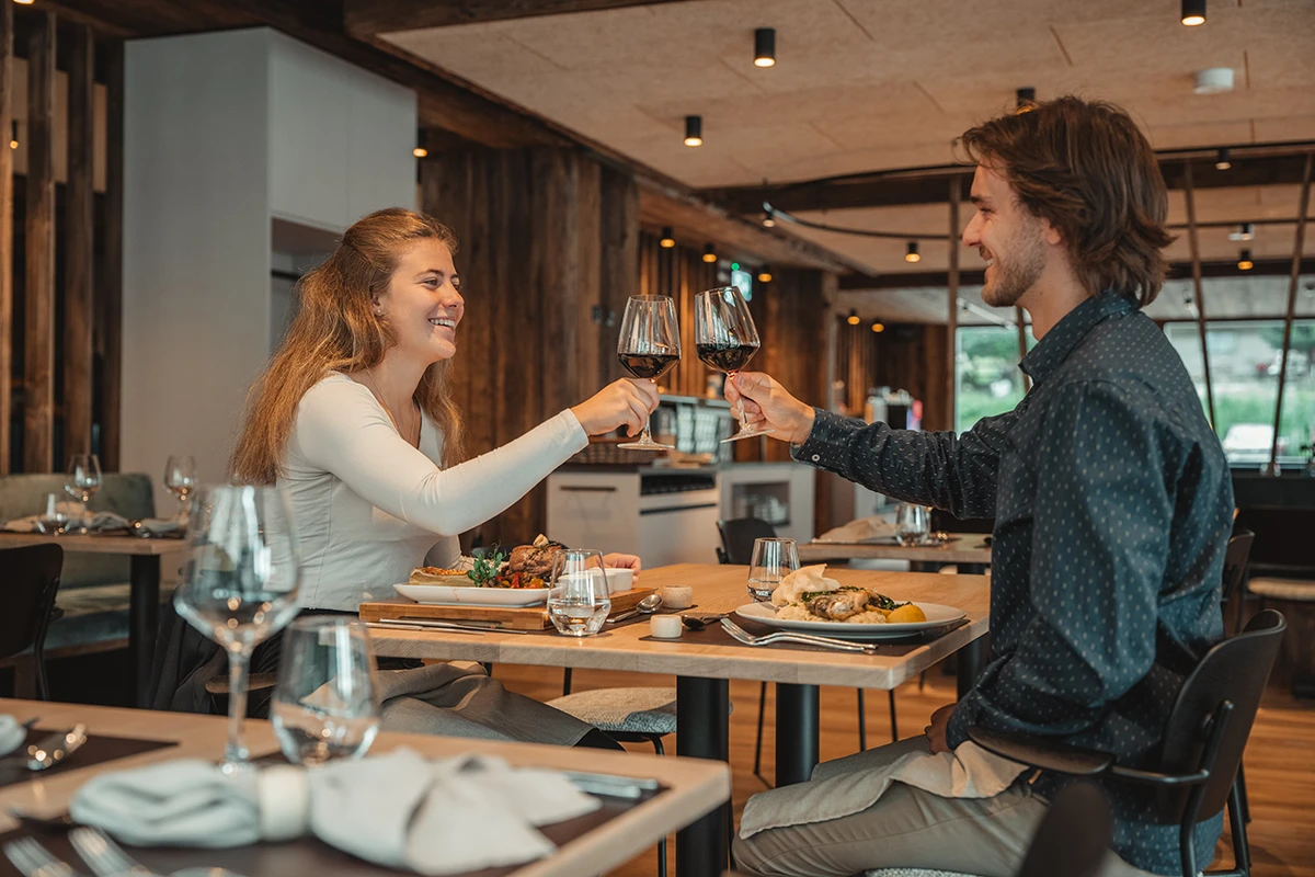 Paar stösst beim Abendessen im Restaurant Ribis & Stibis in Täsch mit Rotwein an