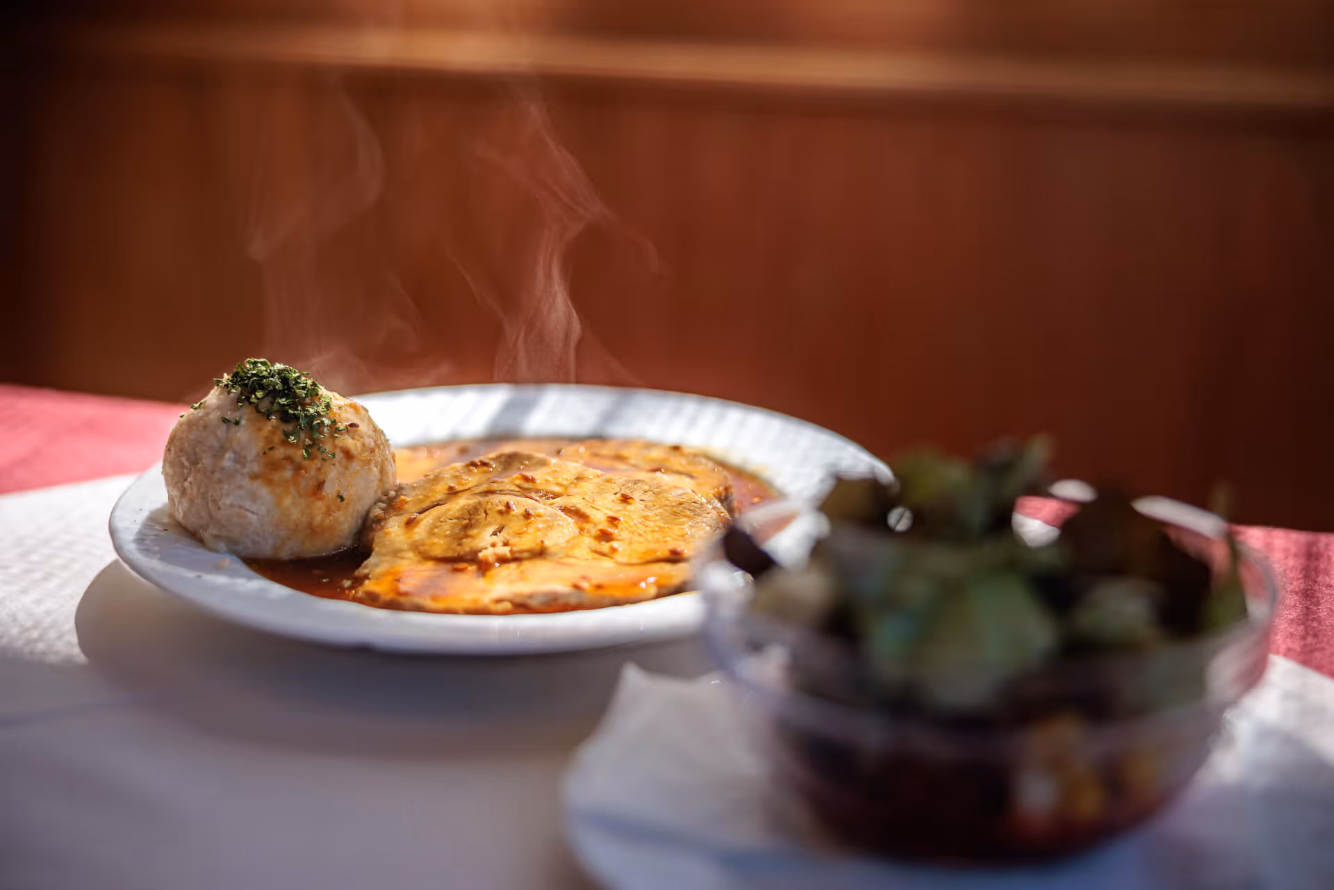 Dampfender Schweinsbraten mit Semmelknödel und Salat im Restaurant Alpengasthof Postl