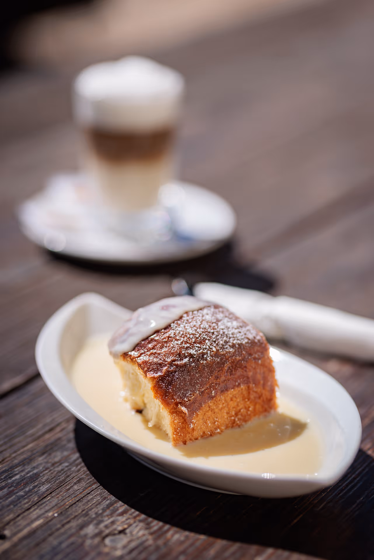 Hausgemachte Süßspeise mit Vanillesauce und Latte Macchiato im Gasthof Postl