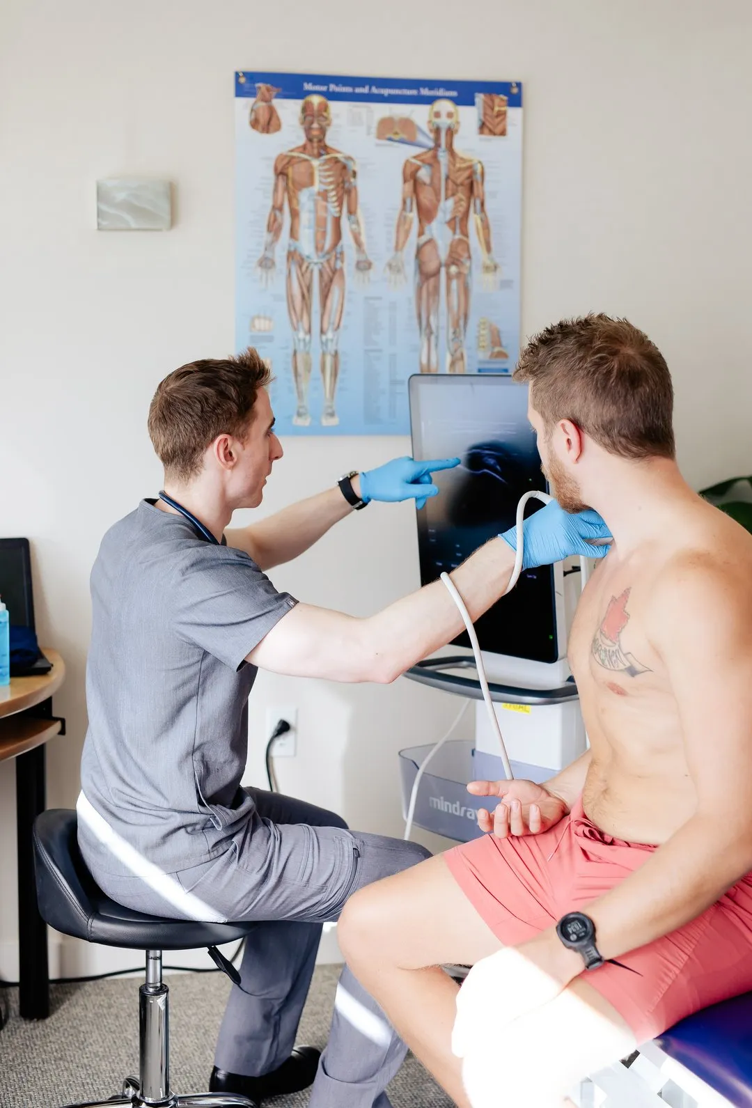 Healthcare professional using ultrasound device on a man's neck during a medical exam.