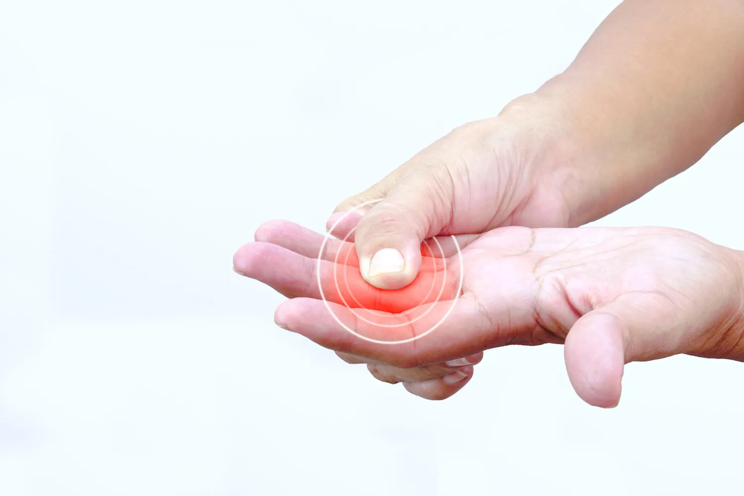 Hand pressing thumb on palm with red target highlighting pain or pressure point.