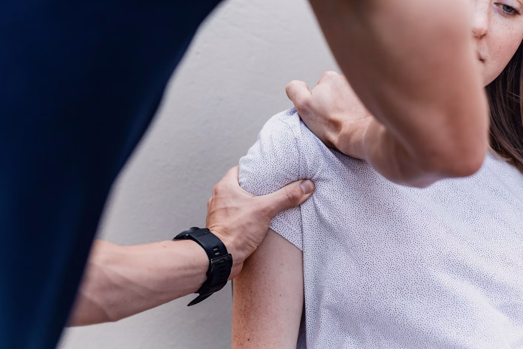 Physical therapist assessing a patient’s shoulder mobility during a clinical examination.