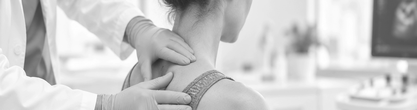 Healthcare professional examining a patient’s neck and upper back during a clinical assessment.