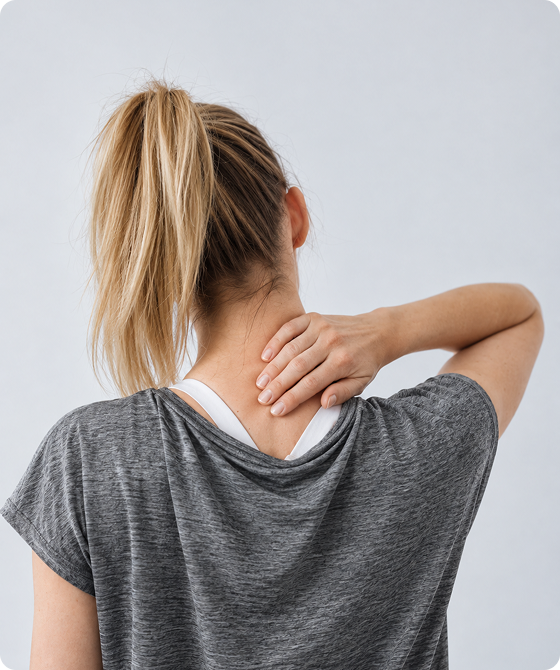 Woman holding the back of her neck, indicating neck pain, stiffness, or muscle discomfort.