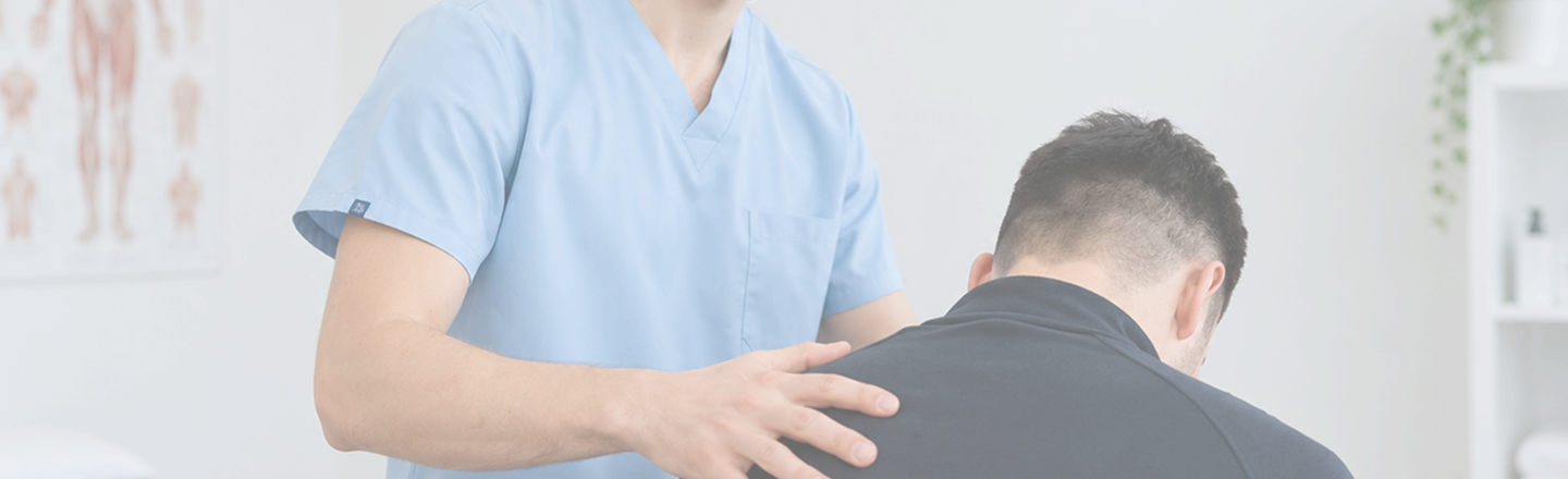 Physiotherapist performing a hands-on upper back and shoulder assessment on a seated patient in a clinical setting.