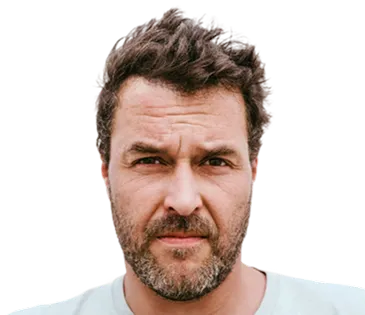 Man with dark hair, beard, and visible forehead lines, looking directly at the camera.