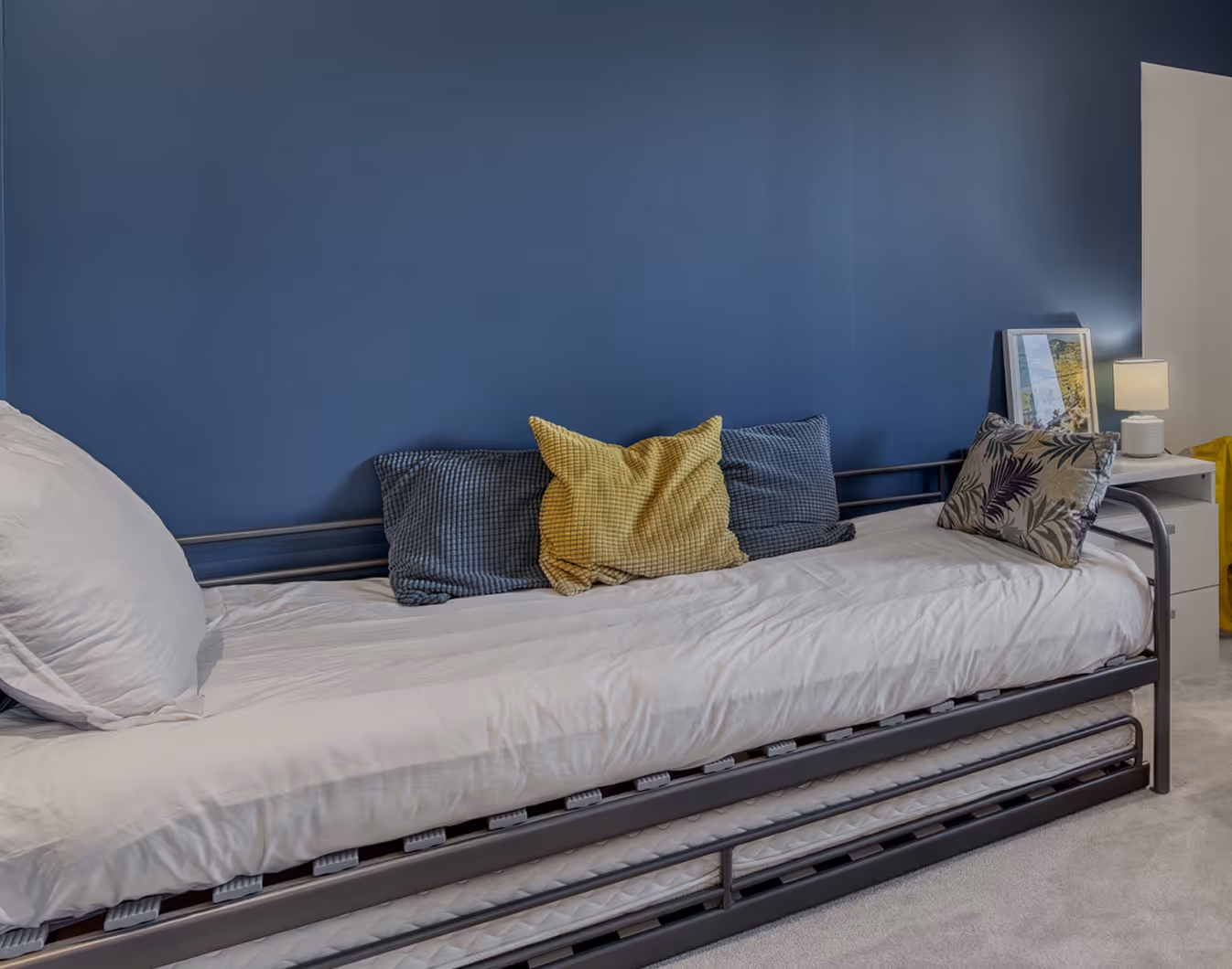 Chambre avec lit double blanc, serviettes roulées, posters de films sur le mur, lampes de chevet stylées.