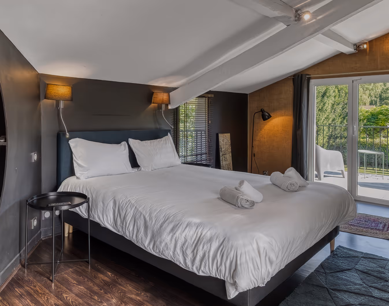 Chambre avec deux lits simples aux draps bleu foncé, fenêtre avec rideaux noirs et cible murale.
